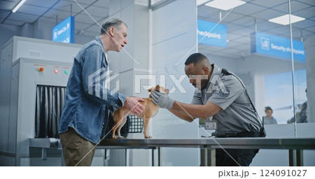 Mature Man with Pet During Screening Procedures in Airport Terminal: TSA Officer Examining Dog 124091027