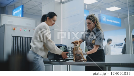 Female TSA Officer Inspects Dog Using Metal Detector Scanner, Places Puppy in Carrier Female TSA Officer Inspects Dog Using Metal Detector Scanner, Places Puppy in Carrier 124091035