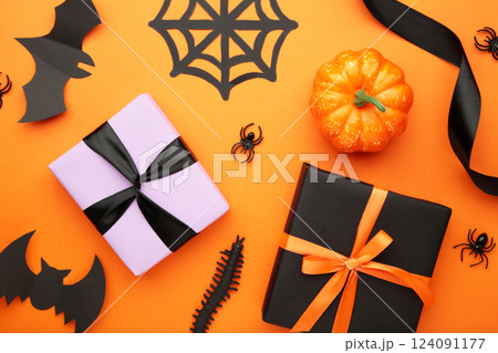 Happy Halloween holiday concept. Flat lay gift boxes, orange pumpkins, bats, spiders on orange background. Halloween greeting card template. Happy Halloween holiday concept. Flat lay gift boxes, orange pumpkins, bats, spiders on orange background. Halloween greeting card template. 124091177