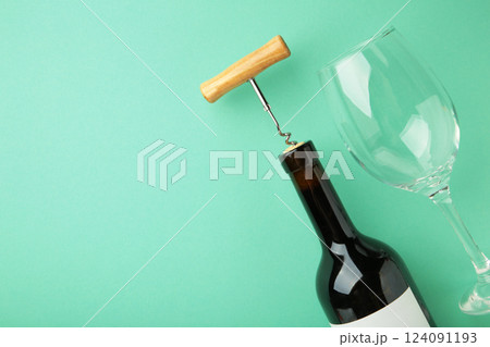 Wine bottle with wine glass and corkscrew lying on mint background. Space for text Wine bottle with wine glass and corkscrew lying on mint background. Space for text 124091193