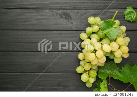 Shine Muscat Grape. Bunch of green grape with leaves on black wooden background. Shine Muscat Grape. Bunch of green grape with leaves on black wooden background. 124091248