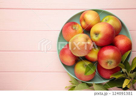 Plate with fresh ripe red apples on pink background. Space for text Plate with fresh ripe red apples on pink background. Space for text 124091381