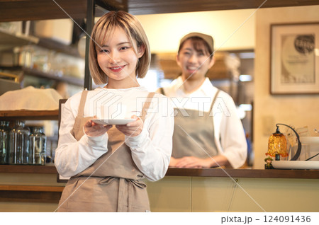 コーヒーカップを持つカフェ店員 124091436