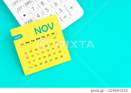 November 2025 calendar page with calculator on blue background. 124091810