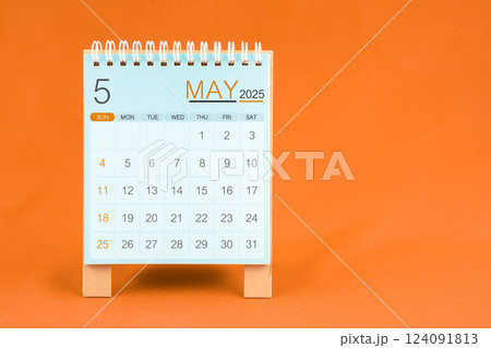 May 2025 desk calendar stand on orange textile background. May 2025 desk calendar stand on orange textile background. 124091813