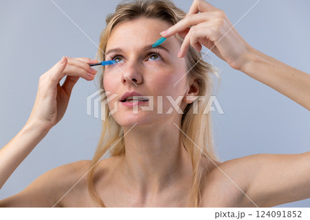 A Young Woman Grooming Her Eyelashes with Precision Tools for a Flawless Makeup Look, Showcasing Beauty and Skincare Rituals 124091852
