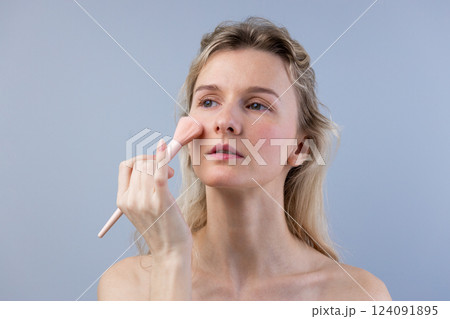 Embracing Beauty: A Serene Moment of Self-Care and Simple Makeup Application Captured in a Relaxed Environment with a Soft Color Palette 124091895
