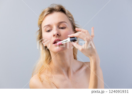 A Beauty Enthusiast Applying Pink Lipstick for a Stunning Look: Perfect Lip Makeup That Enhances Natural Beauty 124091931