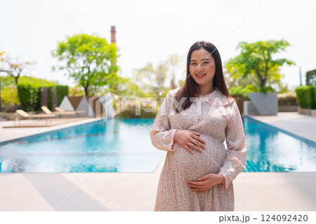 Pregnant woman portrait next to swimming pool 124092420