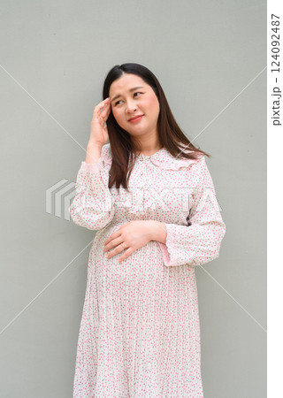 Pregnant woman portrait against plain wall Pregnant woman portrait against plain wall 124092487