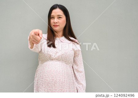 Pregnant woman portrait against plain wall 124092496