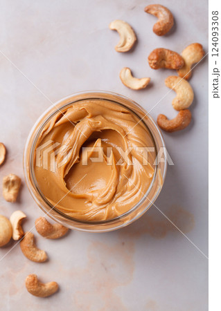 Cashew homemade nut butter in glass jar. Vegan snack concept. Cashew homemade nut butter in glass jar. Vegan snack concept. 124093308