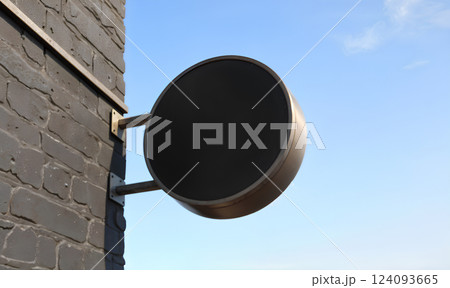 Blank black outdoor round signage mockup wall mounted, sky background. Blank black outdoor round signage mockup wall mounted, sky background. 124093665