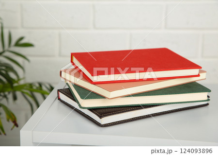 Table with notebooks on a light background. 124093896