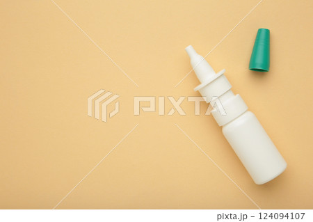 Bottle of nasal drops on beige background. Space for text Bottle of nasal drops on beige background. Space for text 124094107