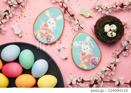 Easter gingerbread and eggs with seasonal flowers on pink background. Sweet Easter concept, greeting card 124094110