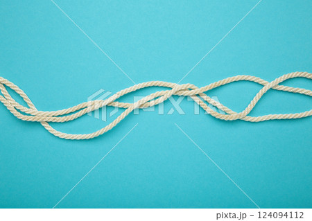 White wavy rope on blue background. Space for text White wavy rope on blue background. Space for text 124094112
