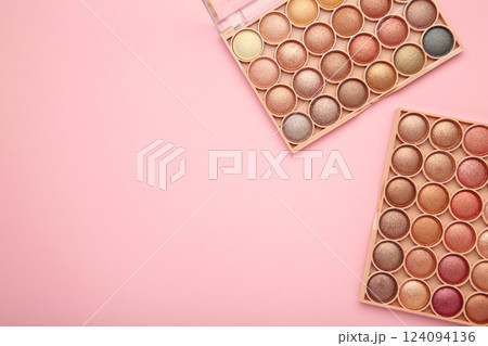 Pastel palette of eyeshadow on pink background. Space for text 124094136