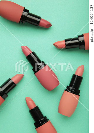 Different pastel lipsticks on mint background. Vertical photo Different pastel lipsticks on mint background. Vertical photo 124094137