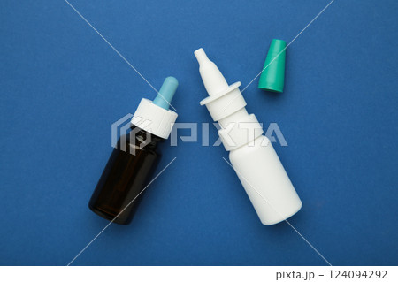 Bottles of nasal drops on blue background. Space for text Bottles of nasal drops on blue background. Space for text 124094292