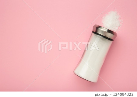 Glass salt shaker on pink background. Space for text 124094322