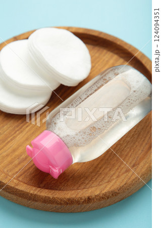 Micellar cleansing water and cotton pads on blue background. Vertical photo 124094351