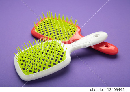 Plastic hairbrushes on violet background. 124094434
