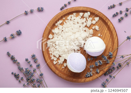 Natural cosmetics. Handmade lavender bath bombs and lavender flowers on wooden board on purple background. Natural cosmetics. Handmade lavender bath bombs and lavender flowers on wooden board on purple background. 124094507