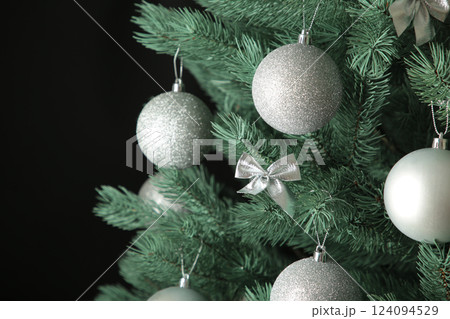Christmas tree with silver balls on dark background. Christmas card with white silver decor 124094529