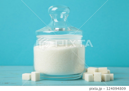Jar with white sugar on blue background. Space for text Jar with white sugar on blue background. Space for text 124094809