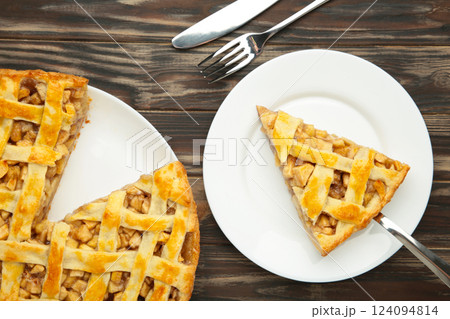 Apple pie and piece of pie on brown background. Copy space. Apple pie and piece of pie on brown background. Copy space. 124094814