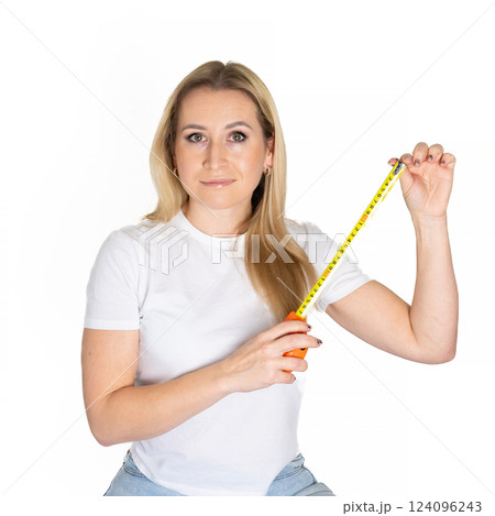 Blonde white woman holds a measuring tape. Roll Measuring Tape In Woman's Hand. building concept Blonde white woman holds a measuring tape. Roll Measuring Tape In Woman's Hand. building concept 124096243