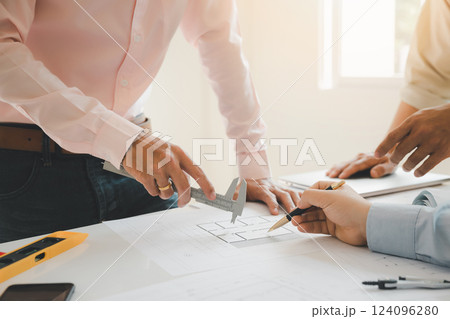 Confident team of architect working together in a office.Then discussing about new startup project on desk. Architect discuss with engineer about project in office, architectural concept. Confident team of architect working together in a office.Then discussing about new startup project on desk. Architect discuss with engineer about project in office, architectural concept. 124096280