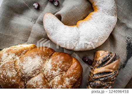 Assortment of fresh baked bread and buns on wooden table background, top view Assortment of fresh baked bread and buns on wooden table background, top view 124096458