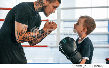 Preparing for the sparring. Coach is teaching the boy box techniques indoors 124096689