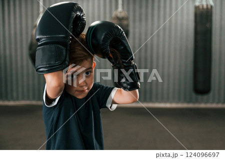 Portrait of boy that is practicing boxing in the gym with glowes on hands 124096697
