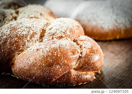 Braided buns bread decorated with sugar above on a wooden table background Braided buns bread decorated with sugar above on a wooden table background 124097105