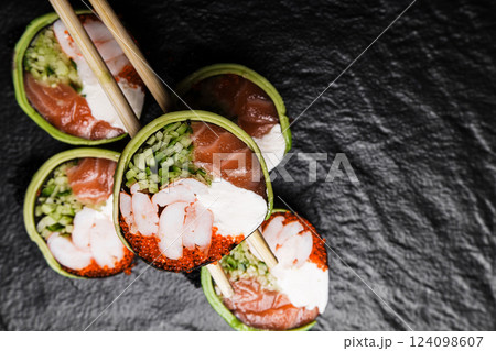Fresh Sushi avocado shrimp Rolls Presenting Exquisitely on a Black Background 124098607
