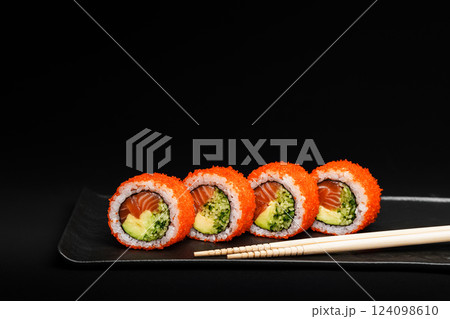 Delicious Fresh Salmon Sushi Rolls Presenting Exquisitely on a Black Background Delicious Fresh Salmon Sushi Rolls Presenting Exquisitely on a Black Background 124098610