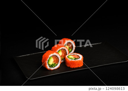 Delicious Fresh Salmon Sushi Rolls Presenting Exquisitely on a Black Background Delicious Fresh Salmon Sushi Rolls Presenting Exquisitely on a Black Background 124098613