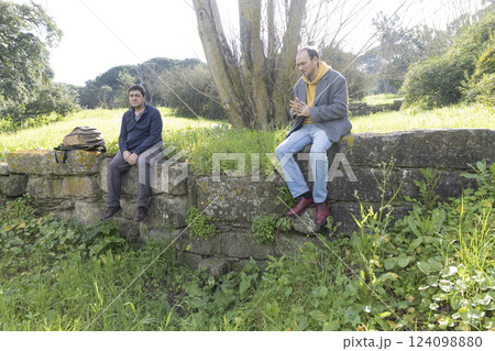 Two archaeologists resting on ancient roman ruins discussing recent findings 124098880