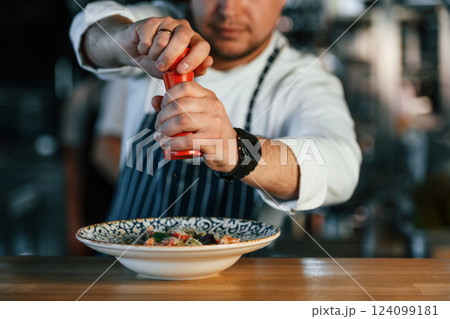 Delicious salad. Chef is on the kitchen preparing food Delicious salad. Chef is on the kitchen preparing food 124099181