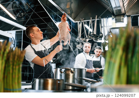 Conception of cooperation. Kitchen workers is together preparing the food Conception of cooperation. Kitchen workers is together preparing the food 124099207