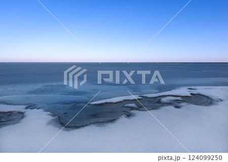 snow-covered lake shore with melting ice snow-covered lake shore with melting ice 124099250