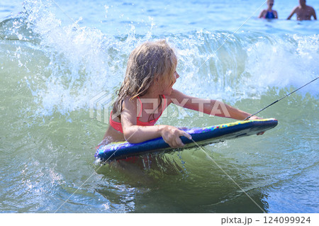 The child is having fun in the sea waves 124099924