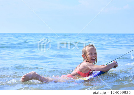 A girl is having fun swimming in the sea on a clear sunny summer day 124099926