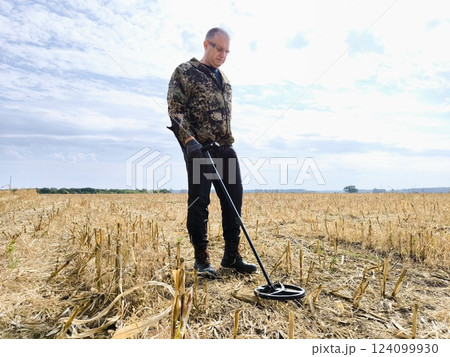 Archeology. man with a metal detector searches for treasures. Man with a metal detector. metal detector at work in the forest or field Archeology. man with a metal detector searches for treasures. Man with a metal detector. metal detector at work in the forest or field 124099930