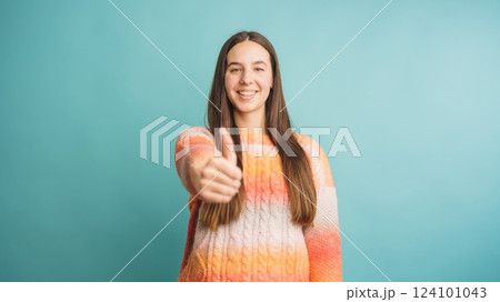 Young woman giving a confident thumbs up gesture 124101043
