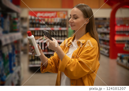 Exploring household chemicals while scanning products in a retail store during daytime shopping 124101207