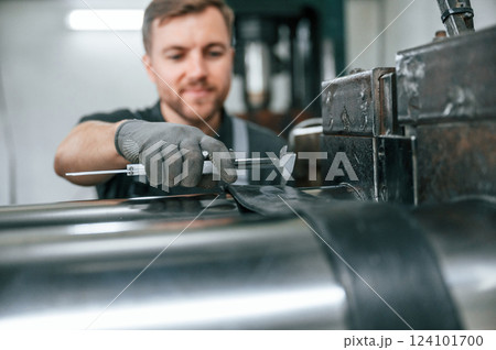 Clean parts. Man in uniform is in workstation developing details of agriculture technique 124101700